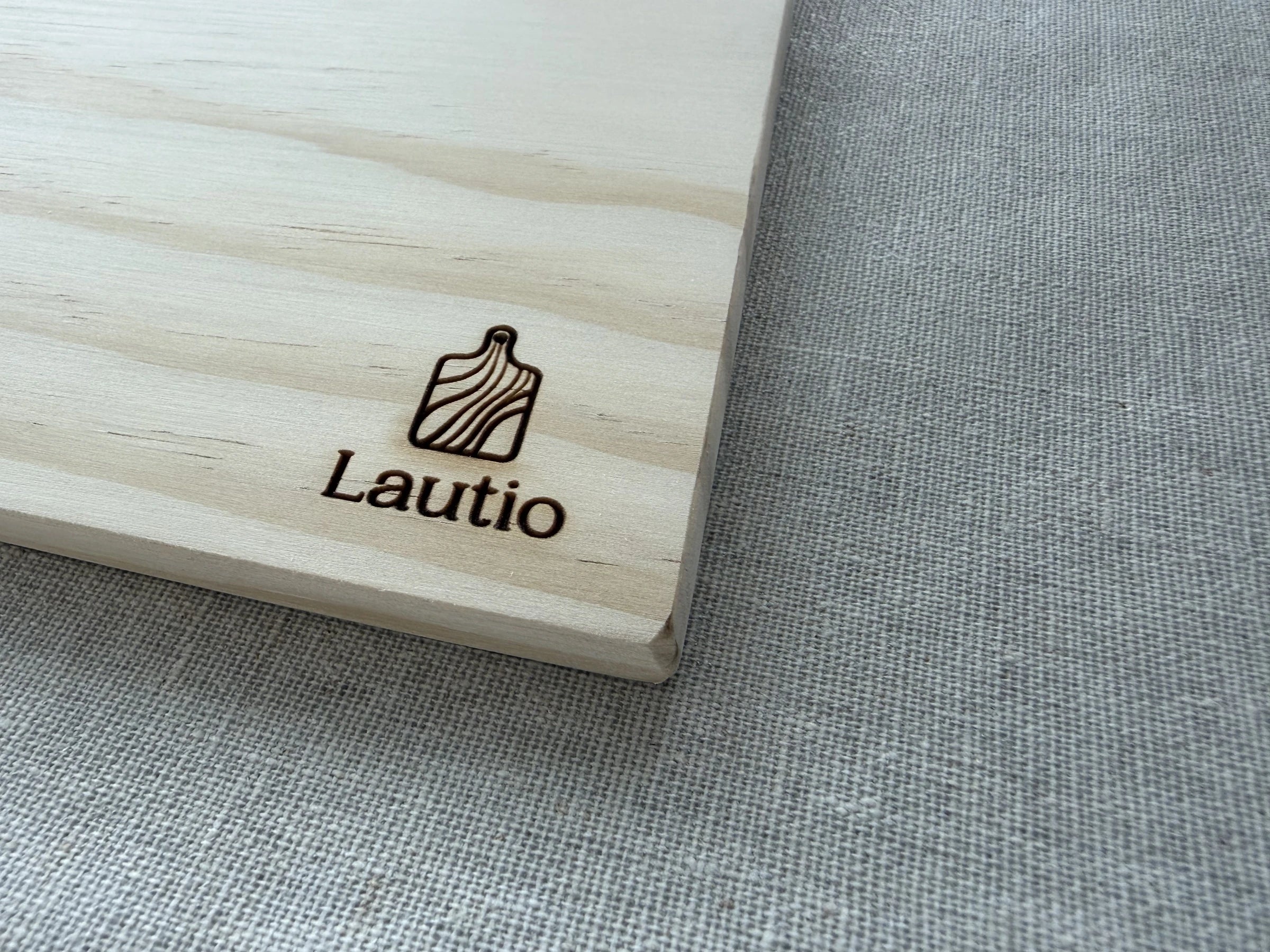 The burnt Lautio mark and the softly rounded corner of a board, on linen